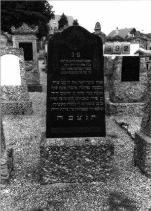 Grabstein 392 (Index: 99797412) Material: Granit, Basalt Zustand: gut Maße HxBxT: 152x54x20 cm Beschreibung: Stele, geschwungener Abschluß, Sockel Symbolik: Kranz mit Schleifen, Ornamentfries: Grabstein 392