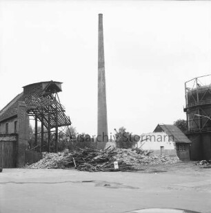 Stadtwerke Bad Oldesloe: Gaswerk: Lübecker Straße: Abriss des Kraftwerks: in der Mitte vor Schornstein Bauschutt: links und rechts teilweise abgerissene Gebäude: rechts dahinter Gasometer: hinten Bäume: 5. Juni 1971