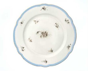 Flacher Teller mit blau bemaltem Rand und Streublumen