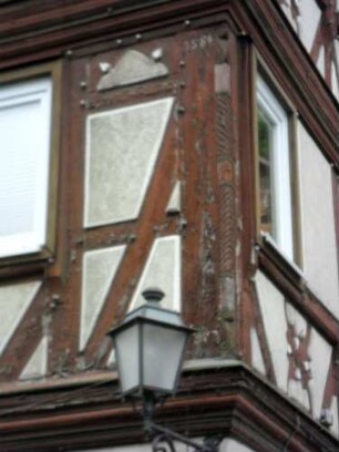 Stadtbild - Hauptstraße - Fachwerkhaus - Nordostecke-erstes Obergeschoß mit Holzschnitzerei und Jahr 1586 sowie Fachwerk mit Holznägeln im Detail