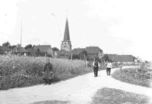 Feldweg mit Bauern, im Hintergrund Kirche