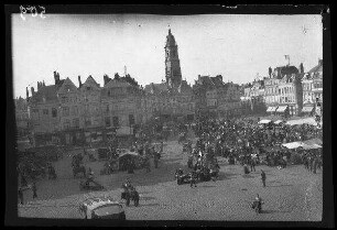 Cambrai (Dep. Nord, Frankreich): Marktplatz mit einer Menschenmenge bei den Marktständen, im Hintergrund der Glockenturm [=Belfried] (Blick von schräg oben)