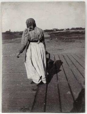 Ohne Titel (Frau mit Korb vor der Silhouette der Westend-Kolonie)