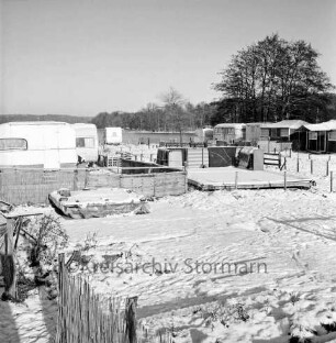Großensee: Südufer: Campingplatz mit winterfesten Wohnwagen und Vorzelten: vorn Wiese: hinten rechts Baum: im Hintergrund Wald: Winter