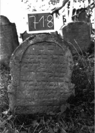Grabstein 718 (Index: 100104811) Material: Sandstein Zustand: verwittert Maße HxBxT: 79x56x13 cm Beschreibung: Stele, stark überhöhter, leicht eingezogener, sehr unregelmäßig gearbeiteter Rundbogenabschluss, Schriftfeld eingetieft: Grabstein 718