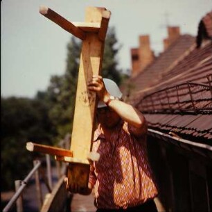 Zimmerer mit Holzbock auf einem Gerüst