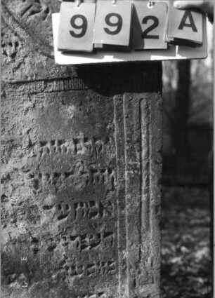 Grabstein 992 (Index: 99751354) Material: Sandstein Zustand: abgeblätt/verwitt/großer Textverlust Maße HxBxT: 122x81x14 cm Beschreibung: Stele, Eselsrückenabschluß, Schriftfeld eingetieft: Grabstein 992A