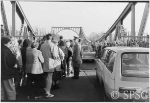 Mauerfall, Potsdam, Glienicker Brücke. Personen und Fahrzeuge überqueren die Glienicker Brücke.