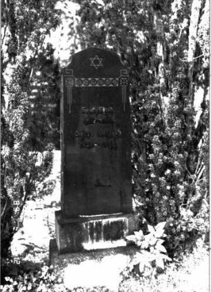 Grabstein 130 (Index: 100101671) Material: Granit, aufgesetzte Metallbuchstaben Zustand: gut Maße HxBxT: 156x48x19 cm Beschreibung: konische Stele, getreppter Sockel, rund eingezogener giebelartiger Abschluß Symbolik: Davidstern, Blütenbordüre Besonderheit: Doppelgrab: Grabstein 130