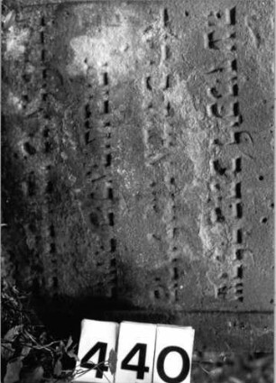 Grabstein 440 (Index: 99803717) Material: Sandstein Zustand: verwittert/eingesunken Maße HxBxT: 110x60x10 cm Beschreibung: Stele mit verdachtem Rundbogen und Giebelfeld: Grabstein 440 (Detailaufnahme)