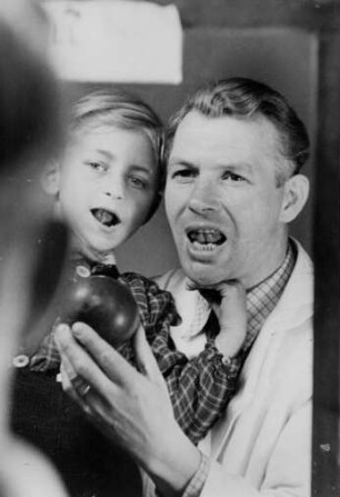 Hamburg. Gehörlosenschule Lerchenfeld. An der Kehlkopfvibration des Lehrers orientiert sich der Schüler an den Lauten des Wortes "Ball". Aufgenommen 1949