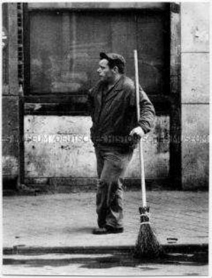 Mann mit einem Besen am Straßenrand (Prämiertes Foto)