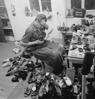 Schuhmacher : Wurzen. Ein Schuhmacher bei der Arbeit, an seinem Arbeitsplatz in seiner Werkstatt, umringt von Werkzeug und Schuhen