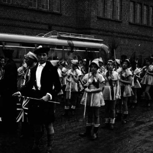Karpfenfest: Umzug: Fischerinnengarde mit Keschern: links "Länder-Kostüm" Schotte: dahinter Reisebus, Ziegelfassade, 8. Oktober 1961