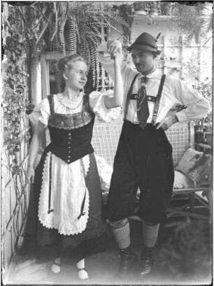 Wohnung der Familie Knochenhauer, Wintergarten? Junges Paar in Tracht (dabei wohl Ilse Stambke) : Kattowitz, Friedensstraße 2. Wohnung der Familie Knochenhauer, Wintergarten? Junges Paar in Tracht (dabei wohl Ilse Stambke)