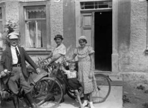 Familie mit Fahrrädern vorm Haus des Fotografen