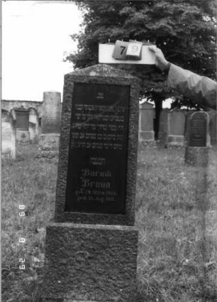 Grabstein 79 (Index: 100108193) Material: Granit, Schriftplatte aus poliertem Granit (oder Marmor?) Zustand: gesprungen Maße HxBxT: 168x48x20 cm Beschreibung: Stele mit satteldachartigem Abschluß, eingelassene Schriftplatte, Sockel: Grabstein 79