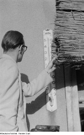 Junger Mann beim Ablesen der Temperatur