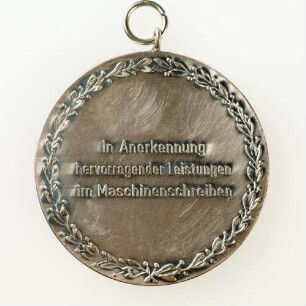 Silbermedaille Deutsche Meisterschaften in Kurzschrift und Maschinenschreiben in Gießen 1977 : Medaillensammlung Stenografische Sammlung. Silbermedaille Deutsche Meisterschaften in Kurzschrift und Maschinenschreiben in Gießen 1977, silberfarben (mit zwei Ösen). Messing, versilbert; Durchmesser 50 mm, Gewicht 50 g (1977; Deschler & Sohn, München). Dresden: SLUB R c 0350