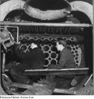 Berlin-Tempelhof. Reichsbahnausbesserungswerk (RAW). Reparaturarbeiten in der geöffneten Rauchkammer einer Lokomotive der Baureihe 52