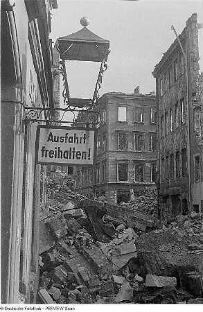 Dresden. Hauswand mit zerstörter Laterne in einer von Trümmerschutt übersäten Straße