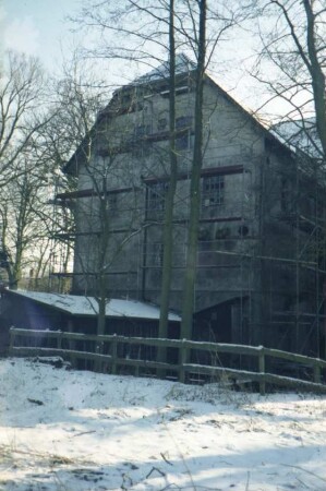 Sühlen: Zur Kupfermühle: ehemalige Kupfermühle [Zettlersche Mühle]: bei Renovierung: Mühlengebäude: Giebelseite mit Gerüst, davor Anbau bei Durchlass von Mühlenbach: vorne Weg, Geländer