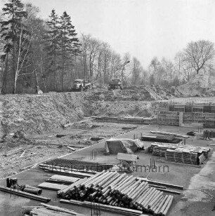 Sachsenwald-Hochhaus: Hinschendorf: Hamburger Straße: Bau: Ausschachtungen und Fundament: Blick in die Baugrube mit Baumaterialien: hinten Verschalungen; dahinter Erdhaufen: darauf in der Mitte zwei Lkws und Bagger: hinten Wäldchen
