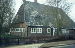 Kruthorst 29: Fachwerkhaus: traufständige Straßenfront: Wohntrakt mit Eingangstür, rechts ehemaliger Wirtschaftstrakt: Giebelseite Wohntrakt: vorne Lattenzaun