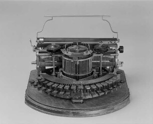 Typenschiffchenschreibmaschine "Hammond" (Modell 3). Vorderanschlag (sofort sichtbare Schrift), Idealtastatur mit 30 Tasten, Farbband. Vorderansicht von oben : Typenschiffchenschreibmaschine "Hammond" (Modell 3). Vorderanschlag (sofort sichtbare Schrift), Idealtastatur mit 30 Tasten, Farbband. Vorderansicht von oben. Baujahr: ab 1880; Hersteller: Hammond Typewriter Co. New York; Verwalter: Sächsische Landesbibliothek - Staats- und Universitätsbibliothek Dresden (SLUB), Stenografische Sammlung, Inventar-Nummer R i 0002