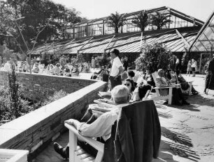 Hamburg. Internationale Gartenbauausstellung auf dem Gelände von Planten un Blomen 1963. Besucher ruhen sich vor den Tropengewächshäusern des Botanischen Garten aus, die sich noch auf dem ehemaligen Gelände des Gartens am Dammtor befinden