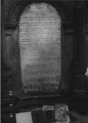 Grabstein 18 (Index: 100109160) Material: Sandstein und Marmor Zustand: Abschluß zerstört, stärker verwittert Maße HxBxT: 127x72x36 cm Beschreibung: Ädikula mit Halbsäulen auf Sockel, Abschluß zerstört, Schrifttafel eingesetzt: Grabstein 18A