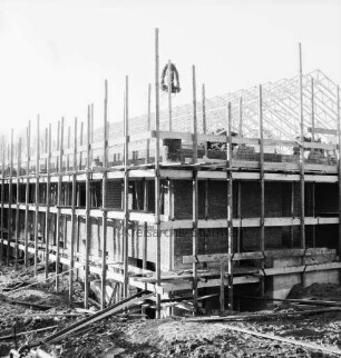 A 1: Raststätte "Buddikate" bei Todendorf und Bargteheide: Richtfest: Rohbau mit Gerüsten, darüber Richtkrone, hinten Dachstuhl, 12. November 1965