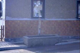 Laufbrunnen im Unterdorf vor einem Haus
