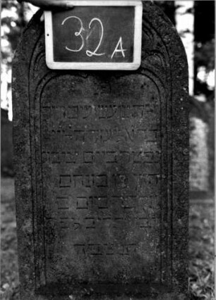 Grabstein 32 (Index: 100111070) Material: Sandstein Zustand: leicht verwittert Maße HxBxT: 116x48x16 cm Beschreibung: Stele, Sockel, Rundbogenabschluß, Schriftfeld eingetieft mit Kleeblattbogenabschluß Symbolik: Levitenkanne, Maßwerk Besonderheit: Kindergrab: Grabstein 32A