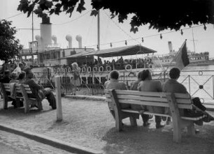 Konstanz am Bodensee. Die Promenade am Hafen. Ein Passagierschiff der Bodensee-Schifffahrt steht zur Abfahrt bereit