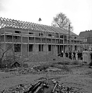 Rathaus: Richtfest: Rohbau mit Gerüst: über Dachstuhl Richtkrone: vorn Baumaterial: hinten rechts Gäste: dahinter Bahnhof Kiekut der Hamburger Hochbahn: hinten Baum