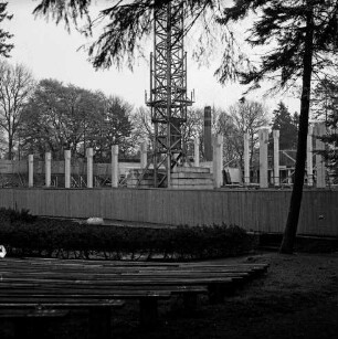 Hallenbad [später Travebad-Schwimmhalle]: Konrad-Adenauer-Ring: Bau: Fundament mit Betonträgern: in der Mitte Baukran: davor und hinten Bauzaun: vorn Bretterstapel: vorn rechts und hinten Bäume