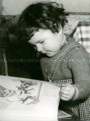 Kind guckt sich ein Buch an