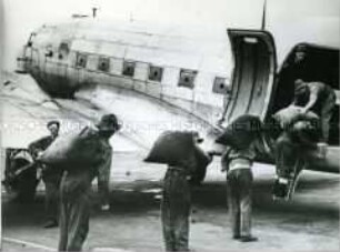 Ein Flugzeug der Luftbrücke wird in Berlin entladen