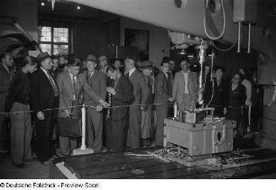 Besucher betrachten einen Bohrer, Technische Messe 1953