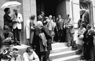 15. Tagung 1965 Physiker; Maikäferrede: Ehepaar Dirac, zwei Frauen im Profil, Sir George P. Thomson, John Bardeen in Rückansicht, Otto Hahn am Mikrofon, Oberbürgermeister Steurer, Rudolf L. Mößbauer, Gustav Hertz, Ehepaar Feodor Lynen, dahinter auf Podest Walter H. Brattain