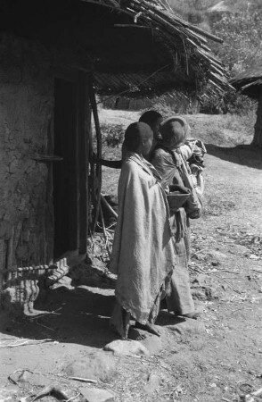 Frauen der Oromo vor einer Rundhütte : Frauen vor ihrer Hütte. Diese befindet sich auf der Grundgebirgsterrasse eines Tals.