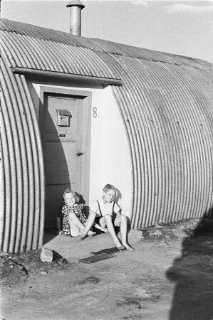 Berlin. Nissen-Hütten (1945/1948) am S-Bahnhof Hohenzollerndamm. Zwei vor der Tür von Haus Nr. 8 sitzende Kinder
