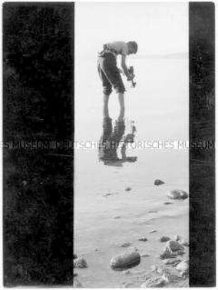 Junge fotografiert im Wasser stehend