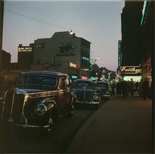 Köln. Leuchtreklame : Köln, Geschäftsstraße mit Leuchtreklame, April 1954