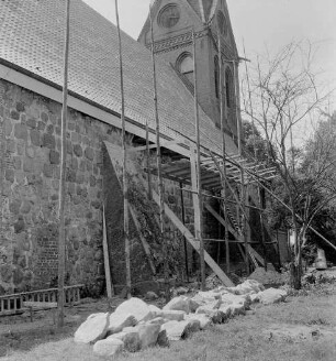Martin-Luther-Kirche: Außenansicht von Nordosten: Renovierung der Nordwand: davor Holzgerüst: rechts herausgebrochene Feldsteine