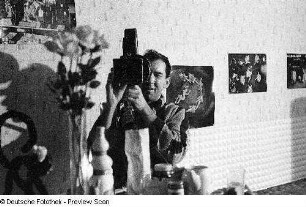 Achim Roth, ein Arbeitskollege des Fotografen an der Deutschen Hochschule für Filmkunst in Potsdam-Babelsberg, mit Filmkamera in einer Wohnung