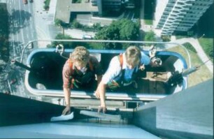 Frankfurt. SGZ-Bank. Blick von oben in eine Zwei-Mann-Gondel mit den beiden Fassadenreinigern bei der Arbeit
