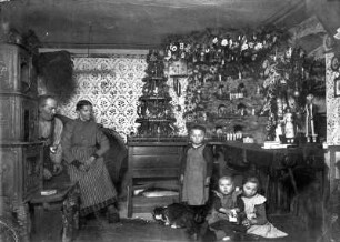 Familie in der Stube mit Weihnachtsberg