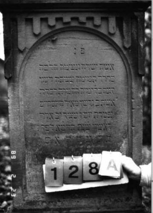 Grabstein 128 (Index: 99751928) Material: Sandstein Zustand: gut Maße HxBxT: 147x56x27 cm Beschreibung: Giebel m. Mittel-u. Eckakroteren, Schriftfeld eingetieft m. Rundbogenabschluß Symbolik: Ranken, Blätter, gestelztes Rundbogenfries: Grabstein 128A